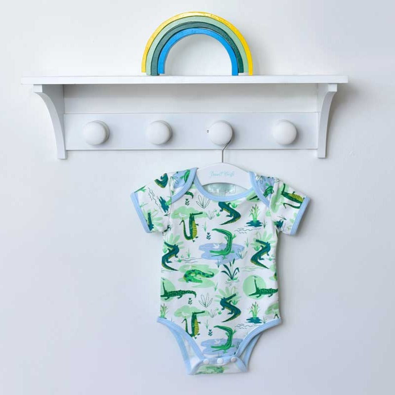 Crocodile Print Baby Grow hanging on shelf